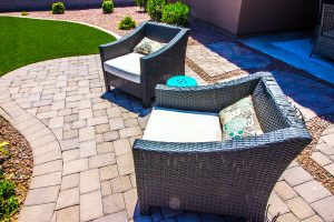 A paver patio with wicker outdoor furniture.